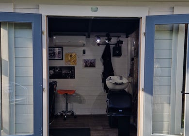 The Garden Salon Hair Design's open door showcases a cozy interior in Colchester, England, GB.