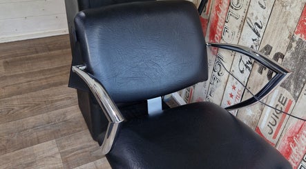 Modern salon chair at The Garden Salon Hair Design, Colchester, England, GB, on rustic wooden floor.