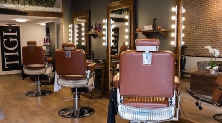 Modern styling chairs at Clean Cut salon in Budapest, Magyar, HU, featuring sleek mirrors and ambient lighting.