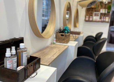 Intérieur élégant du salon Biocoiff Vincennes à Vincennes, Île-de-France, FR avec miroirs circulaires et produits.