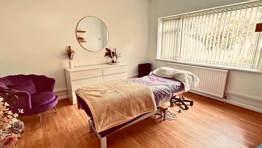 Relaxing treatment room at The Lash & Brow Co, Maidenhead, England, GB with a plush chair and massage table.
