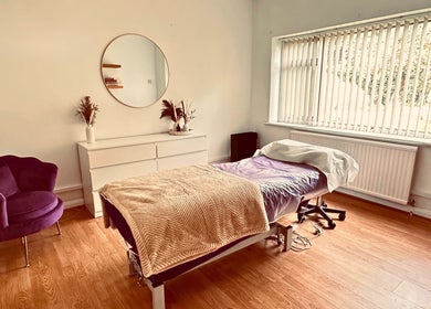 Relaxing treatment room at The Lash & Brow Co, Maidenhead, England, GB with a plush chair and massage table.