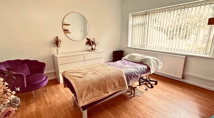 Relaxing treatment room at The Lash & Brow Co, Maidenhead, England, GB with a plush chair and massage table.