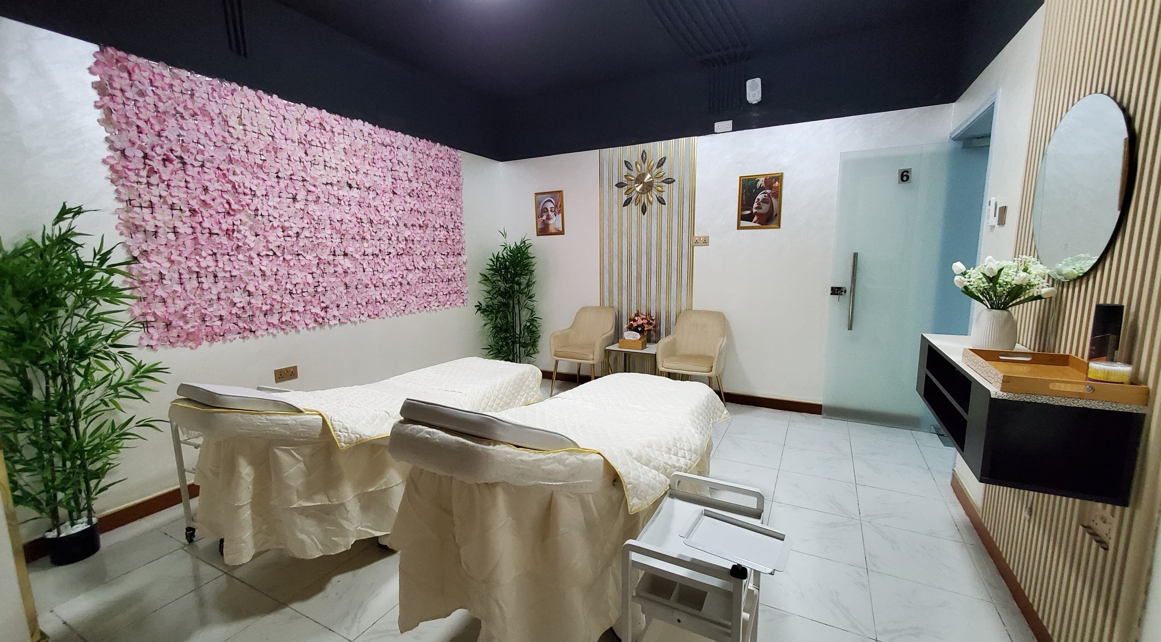 Elegant treatment room at Modiva Spa and Wellness, Al Ain, Abu Dhabi, AE with pink floral decor and twin beds.