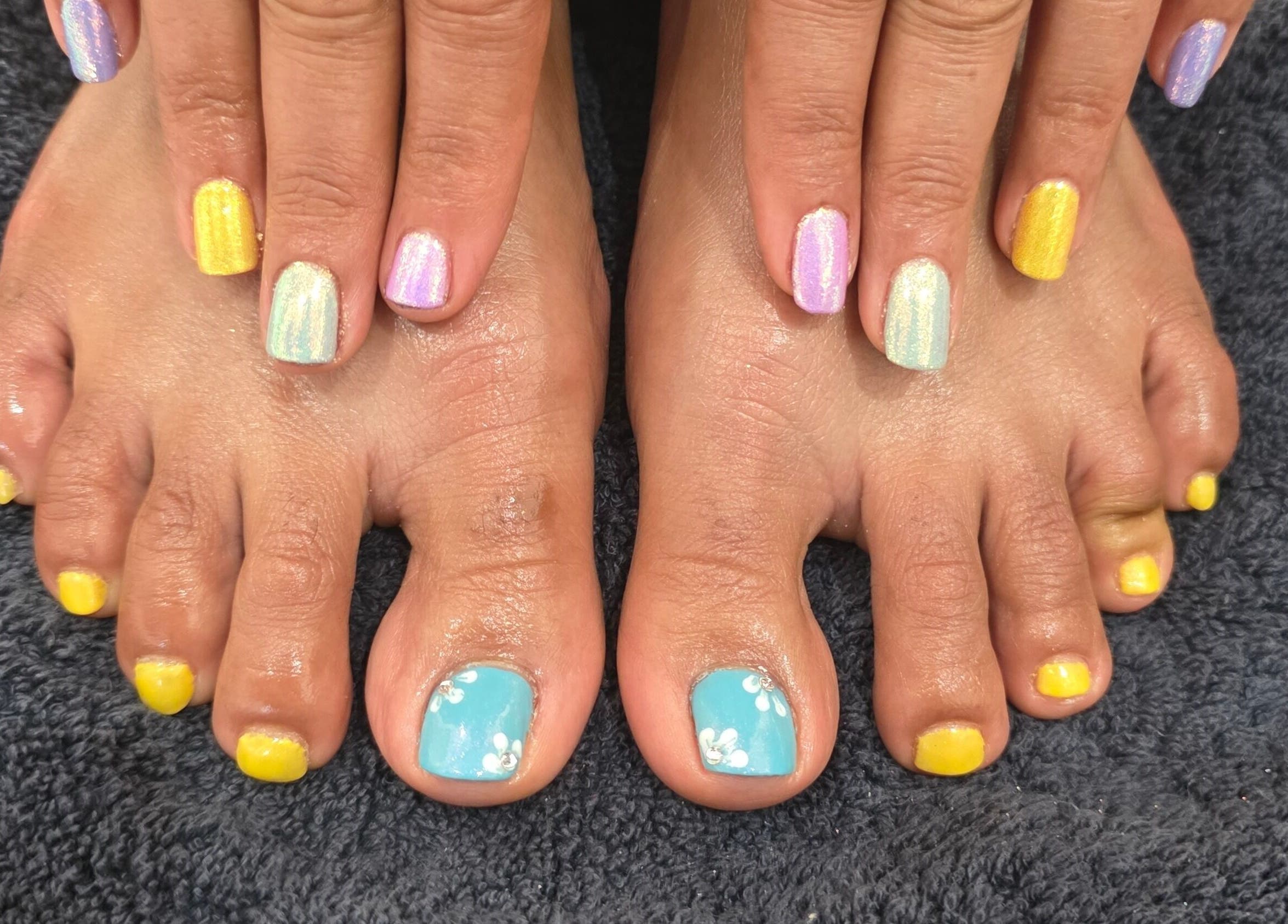 Vibrant nail art on hands and feet at NailsbyAjita, Northwood, England, GB.