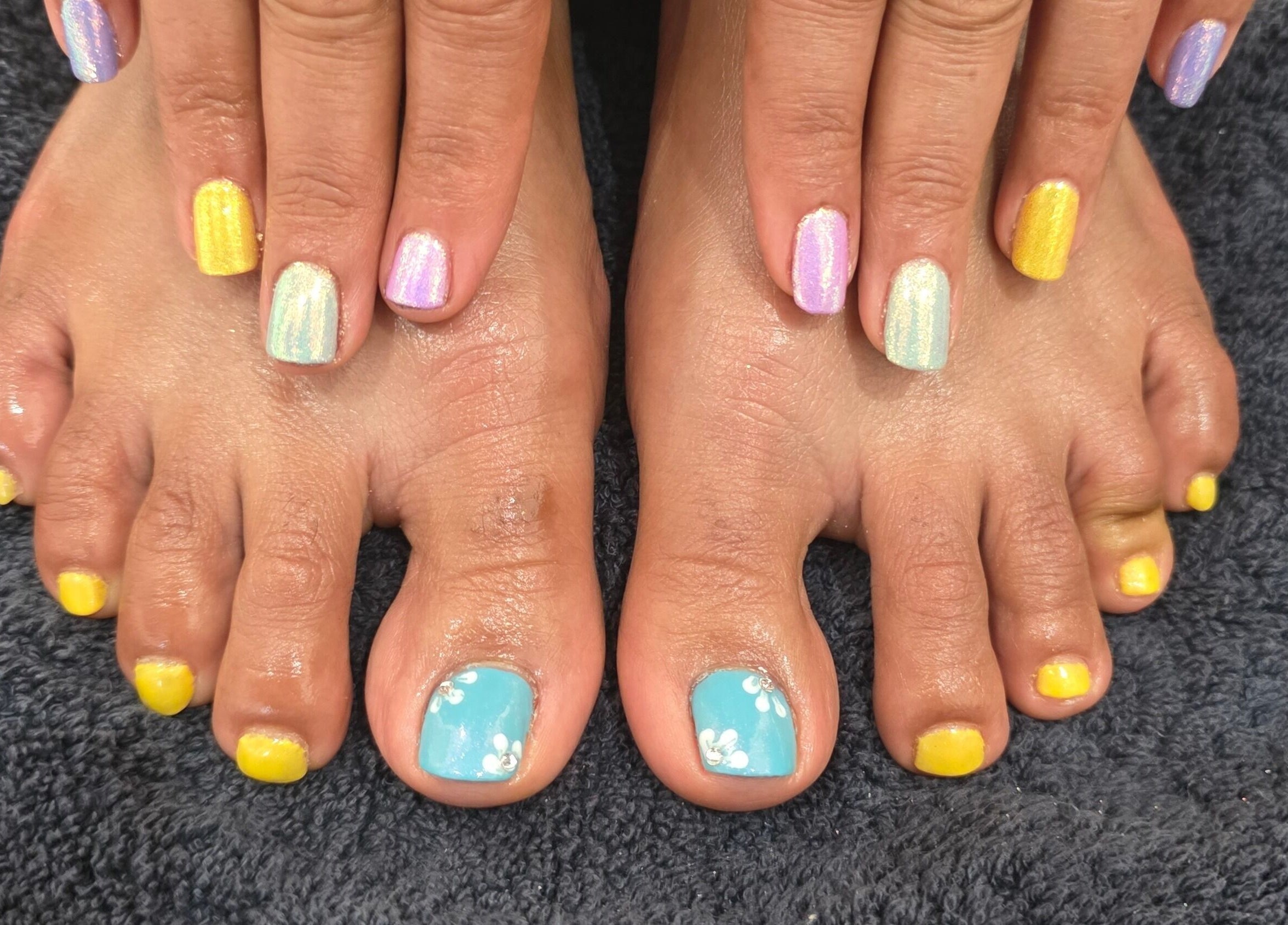 Vibrant nail art on hands and feet at NailsbyAjita, Northwood, England, GB.