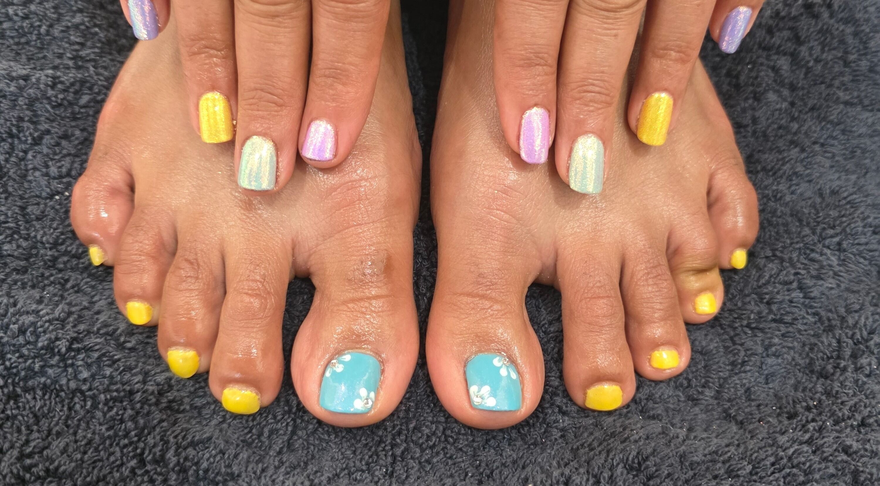 Vibrant nail art on hands and feet at NailsbyAjita, Northwood, England, GB.