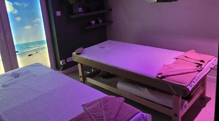 Pokój masażu Prana Thai Spa - Wola, Warszawa z nastrojowym oświetleniem i widokiem na plażę.