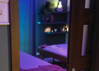 Pokój masażu w Prana Thai Spa - Wola, Warszawa, Województwo Mazowieckie, PL ozdobiony roślinami i świecami.