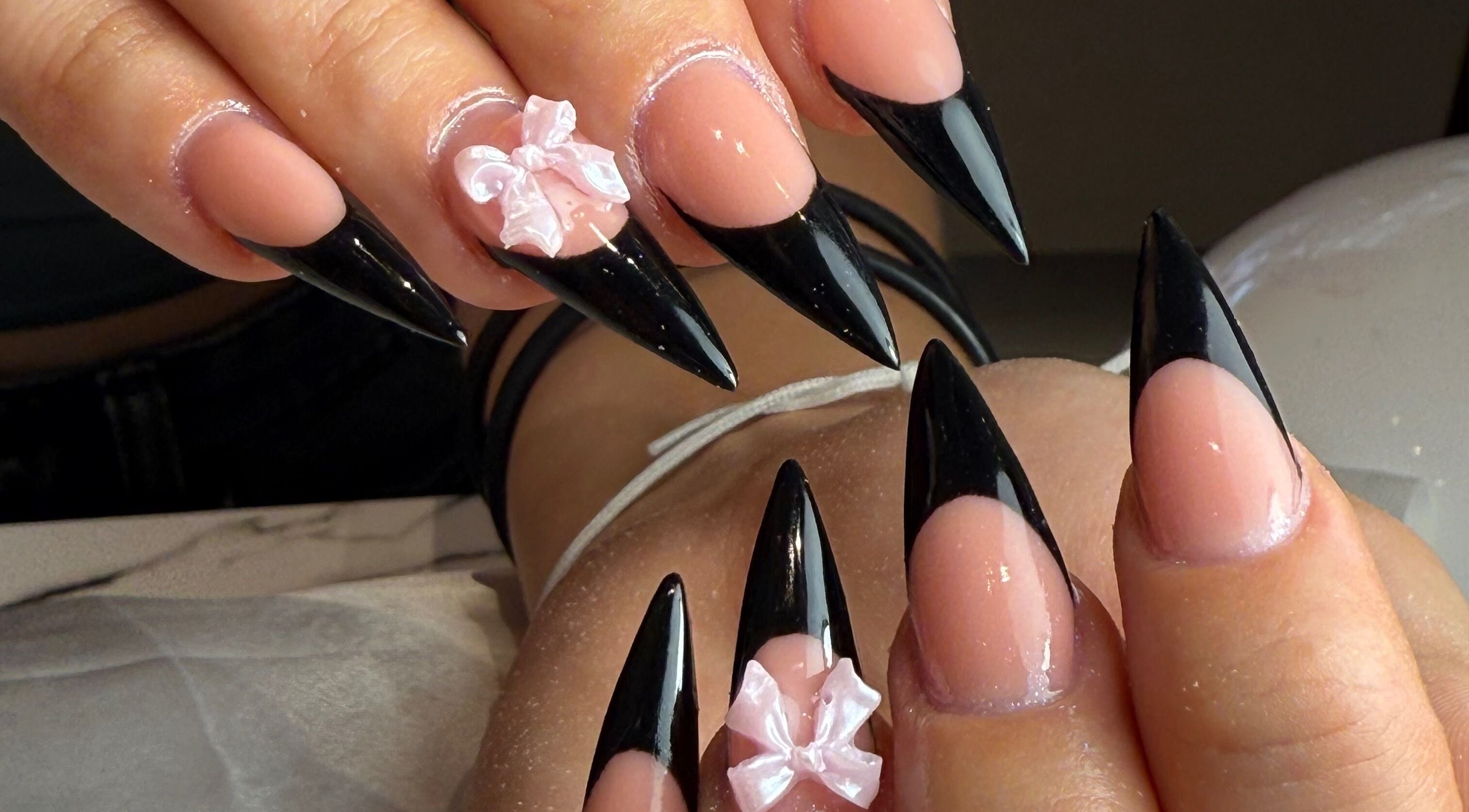 Manucure élégante avec pointes noires et nœud rose chez Amarena Nails, Mons, Région Wallonne, BE.
