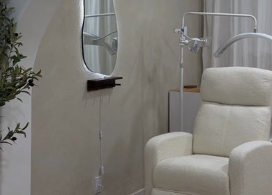 Cozy treatment room at First Gen Beauty in Grover Beach, California, US, featuring a plush chair and ambient decor.