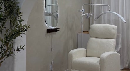 Cozy treatment room at First Gen Beauty in Grover Beach, California, US, featuring a plush chair and ambient decor.