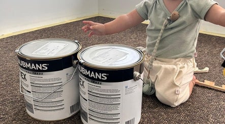 Child with paint cans at Tiny Tree Kids Yoga, Broadbeach, Queensland, AU.