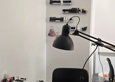 Flexia Ongles & Soins workspace in Saint-Jacques, CA showcasing nail polish collection and a modern lamp.