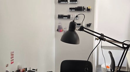 Flexia Ongles & Soins workspace in Saint-Jacques, CA showcasing nail polish collection and a modern lamp.