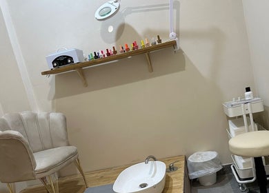 Relaxing pedicure space at Glam Nails by Sheemu in Roma, Lazio, IT, featuring elegant seating and nail polish display.