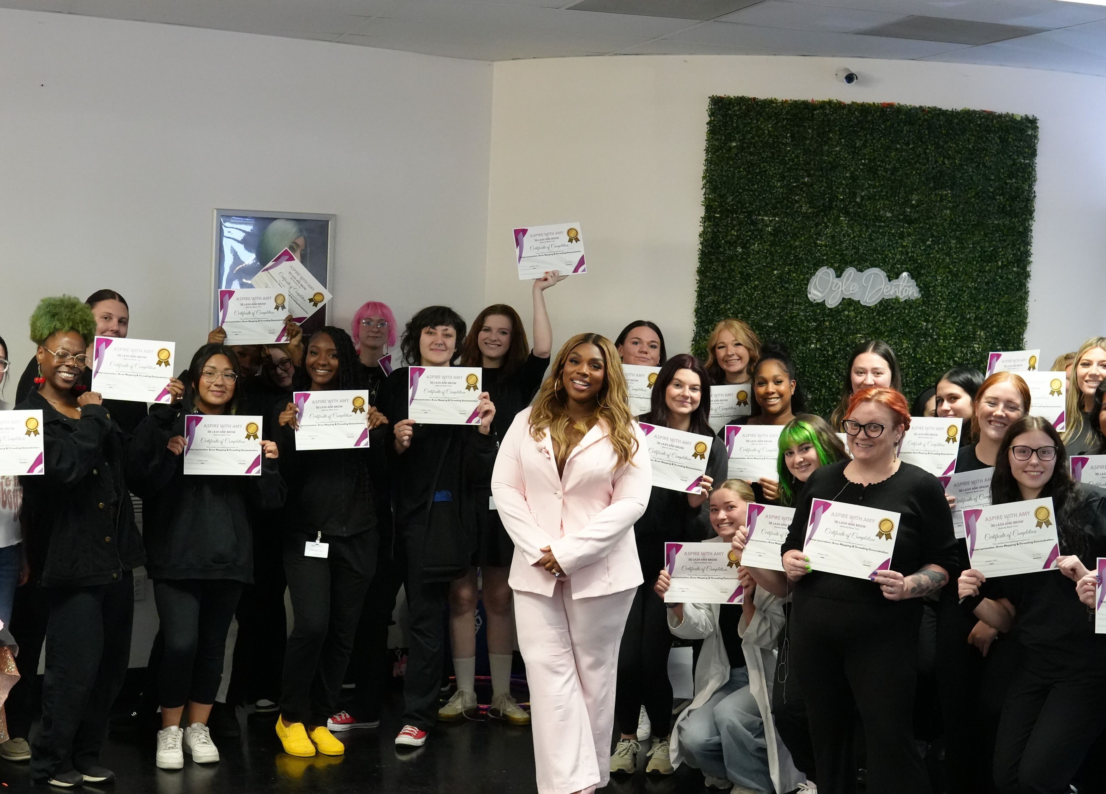 Graduates celebrate at 3D Lash & Brow Academy in Dallas, Texas, US, holding certificates with pride.
