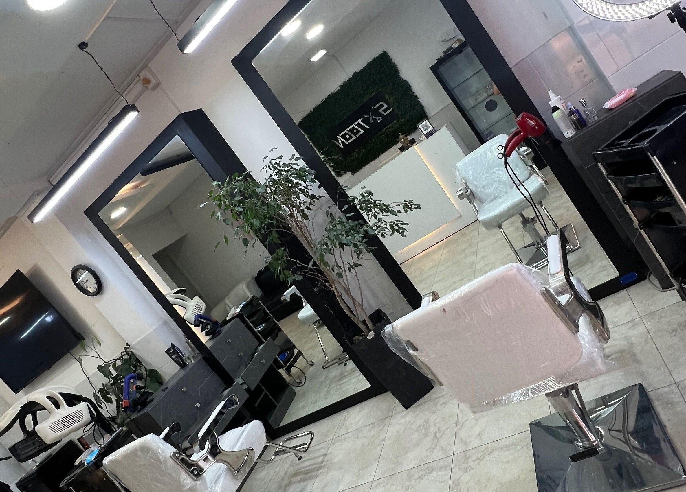 Interior of Sixteen Hair Studio in Ambato, Tungurahua, EC featuring modern styling chairs and mirrors.