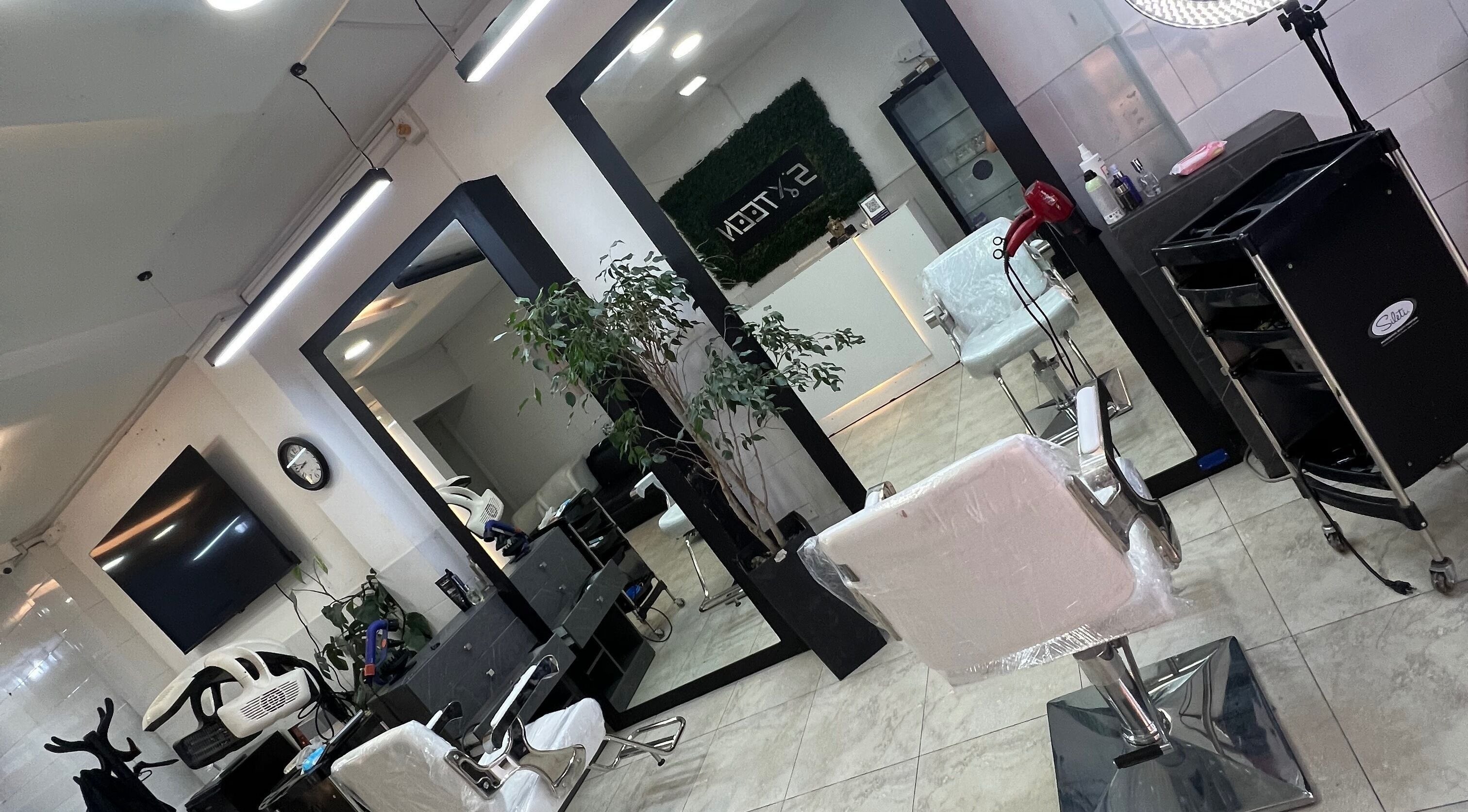 Interior of Sixteen Hair Studio in Ambato, Tungurahua, EC featuring modern styling chairs and mirrors.