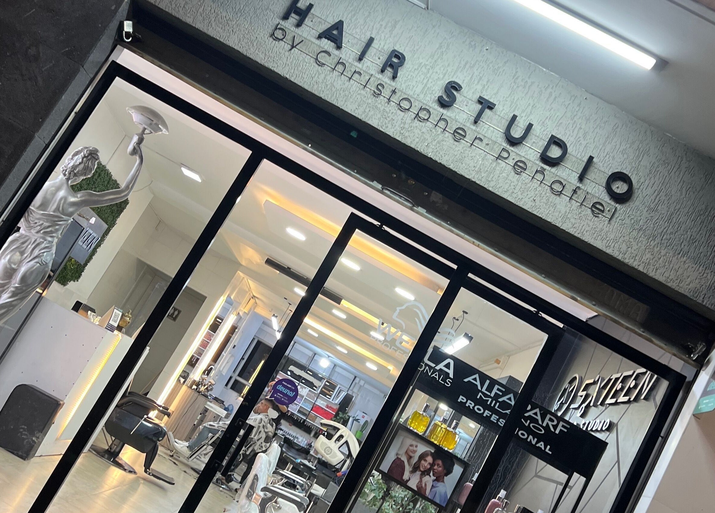 Entrance of Sixteen hair studio in Ambato, Tungurahua, EC with stylish interior visible.
