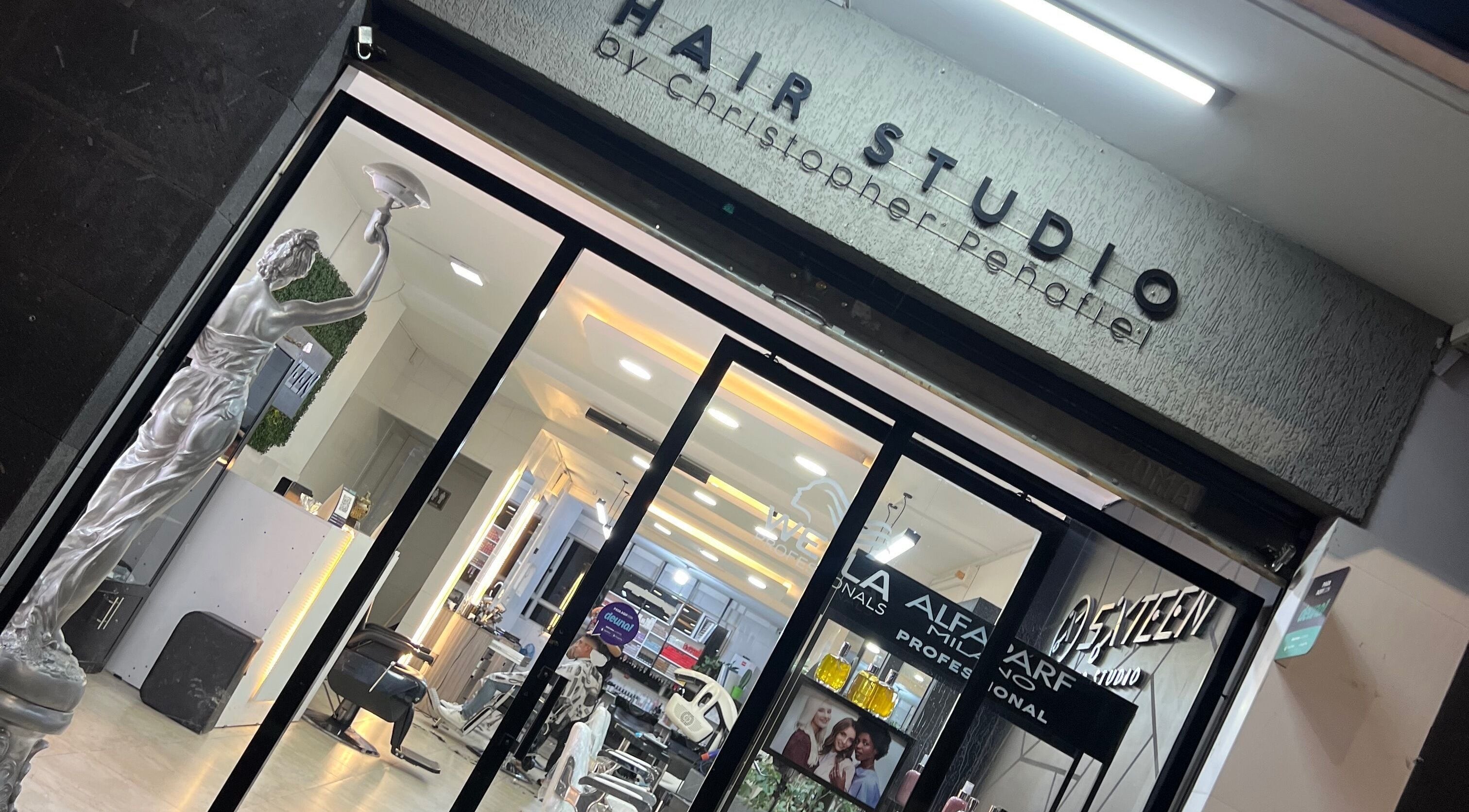 Entrance of Sixteen hair studio in Ambato, Tungurahua, EC with stylish interior visible.