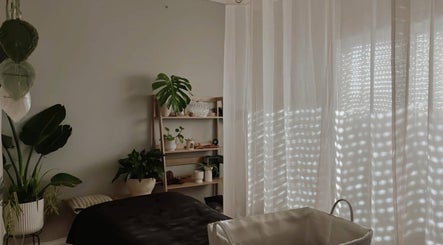 Calming therapy room at SASA Beauty Studio, Saint Albans, Victoria, AU with lush plants and soft curtains.