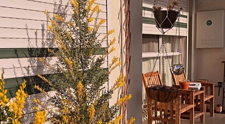 Charming patio at SASA Beauty Studio in Saint Albans, Victoria, AU, featuring vibrant yellow blooms and cozy seating.