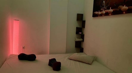 Relaxing massage room with red lighting at Chris Massages, Berlin, Berlin, DE for tranquil therapy sessions.