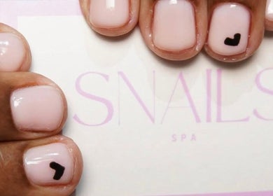 Stylish manicure with tiny black heart design at Snails, Riyadh, Riyadh Province, SA.
