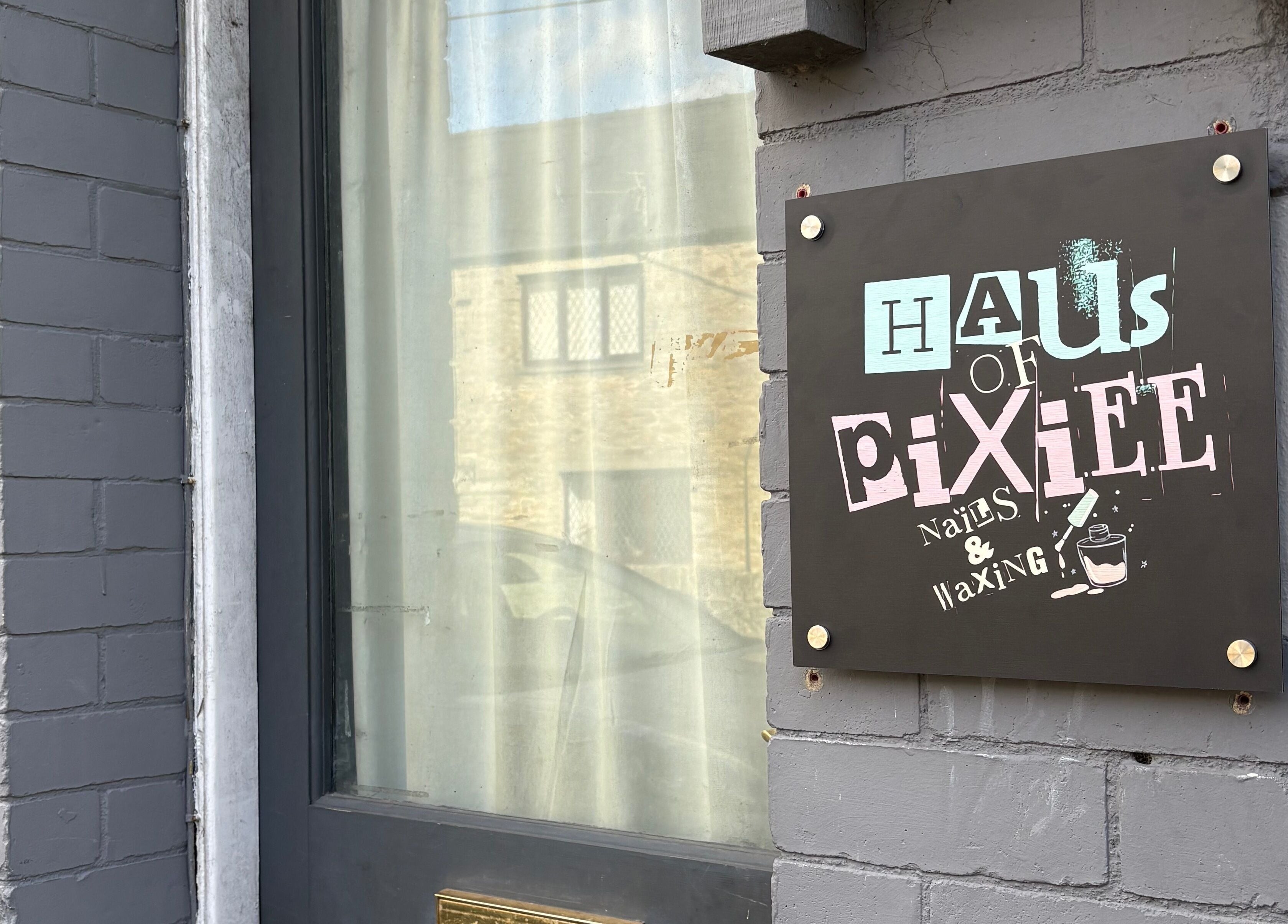 Entrance sign for Haus of Pixiee, Pontyclun, Wales, GB, offering nails and waxing services.