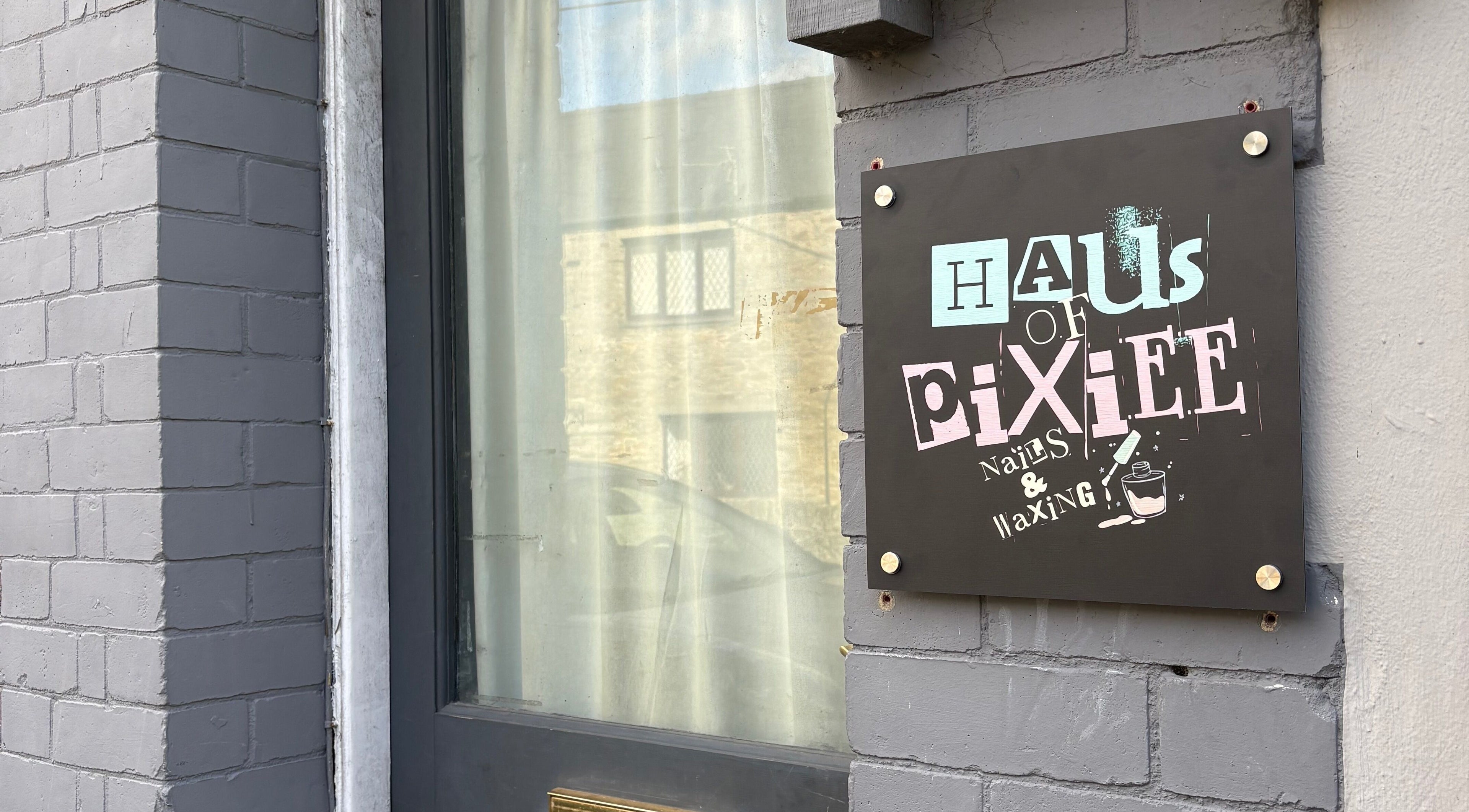 Entrance sign for Haus of Pixiee, Pontyclun, Wales, GB, offering nails and waxing services.
