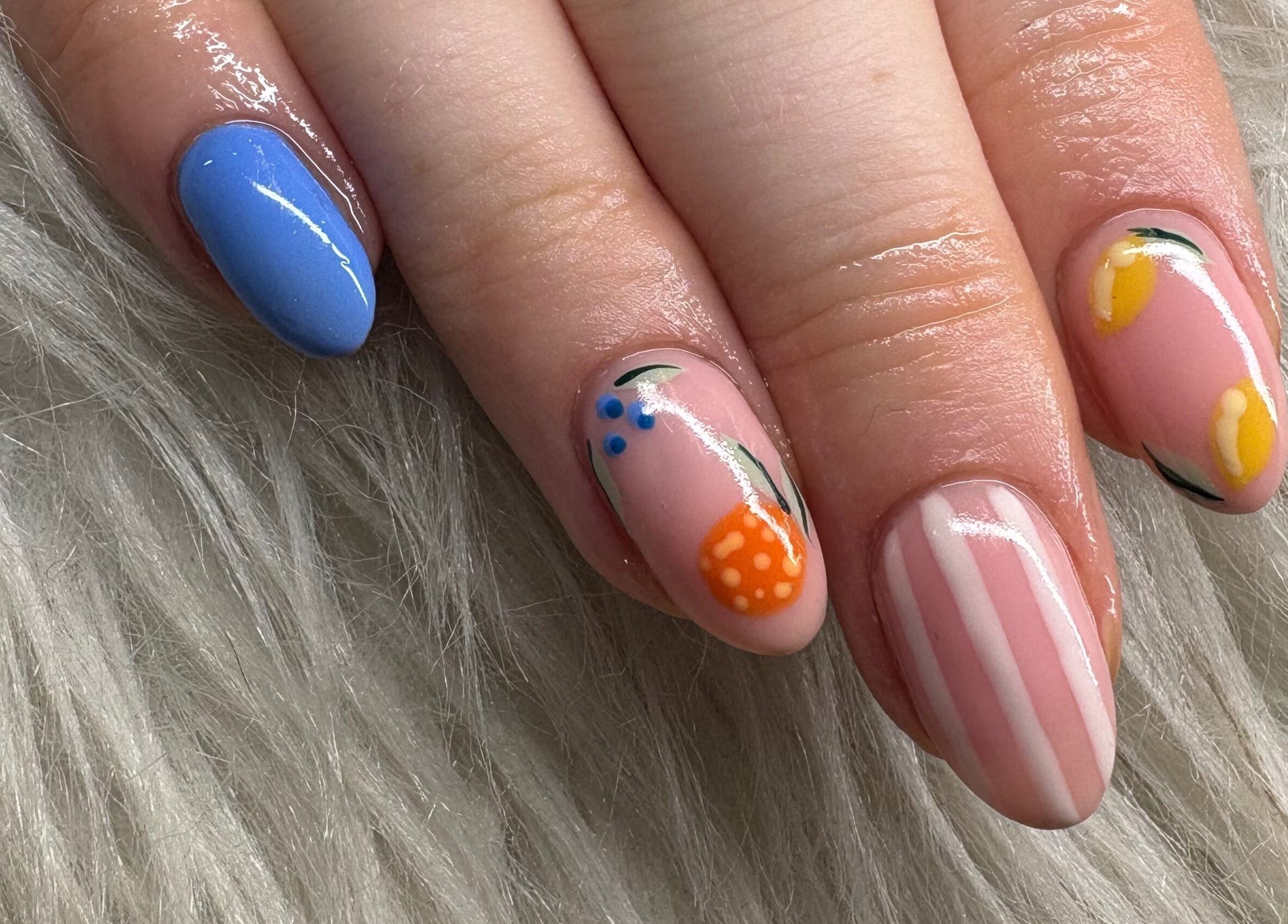 Colorful nail art at Haus of Pixiee, Pontyclun, Wales, GB. Features blue, orange, and yellow designs.