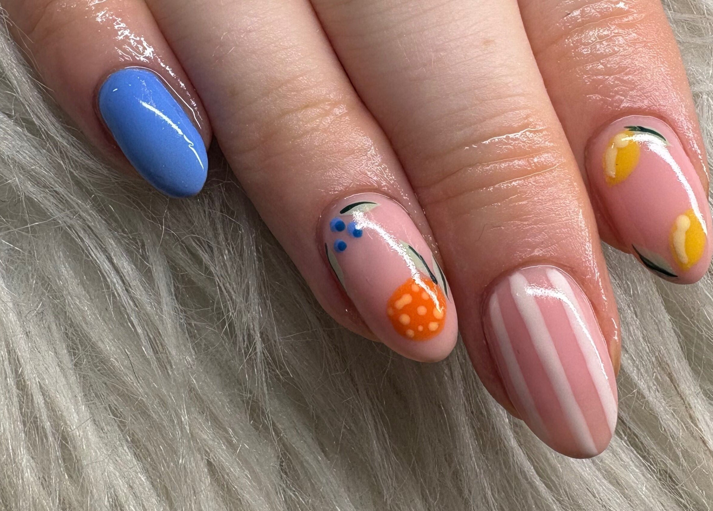 Colorful nail art at Haus of Pixiee, Pontyclun, Wales, GB. Features blue, orange, and yellow designs.