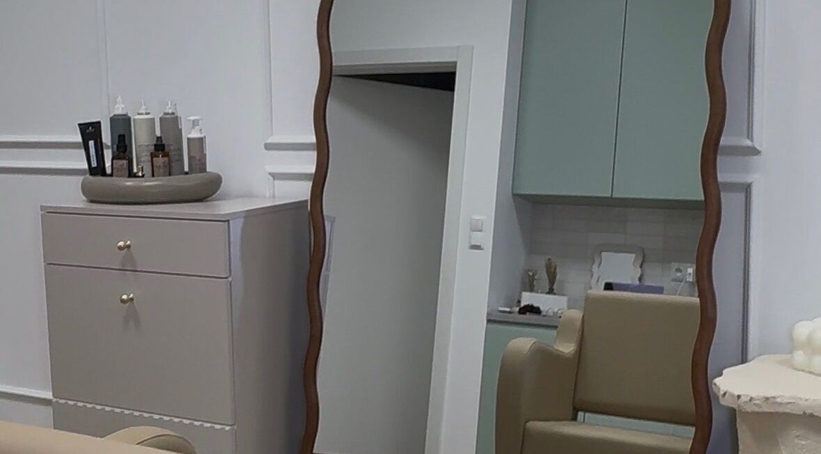 Stylowe wnętrze Waves Studio w Andrychowie, Województwo Małopolskie, PL z ozdobnym lustrem i kosmetykami.