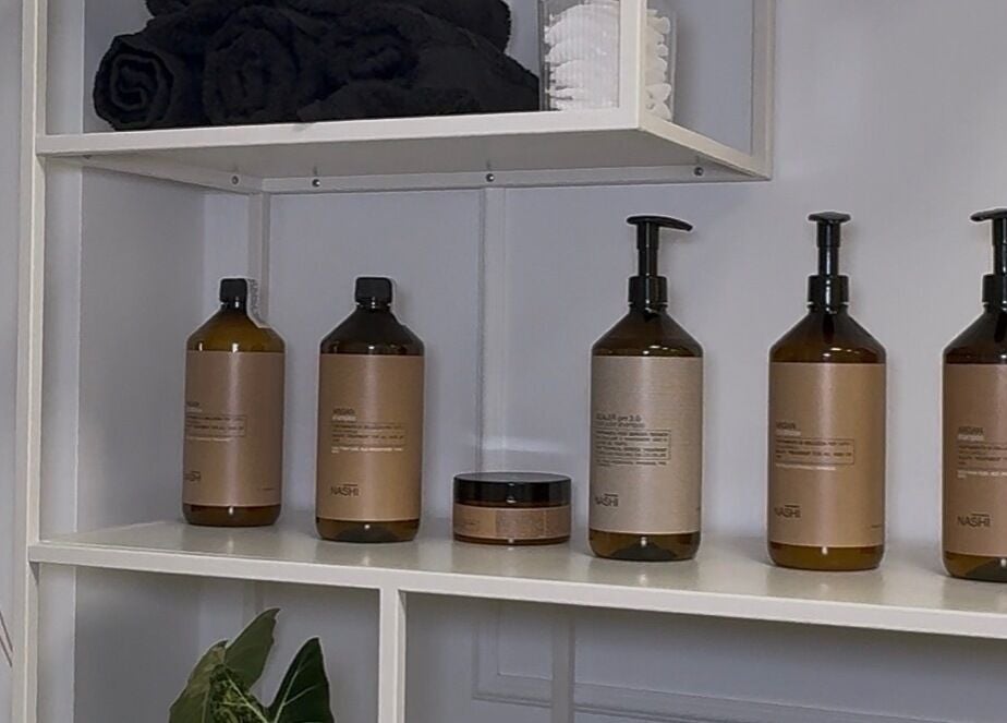 Wyposażenie Waves Studio, Andrychów, Województwo Małopolskie, PL z produktami do pielęgnacji i ręcznikami.