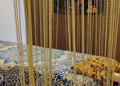 Sala massaggi La Magia dell'Anima a La Spezia, Liguria, con un lettino decorato e tenda a fili dorati.