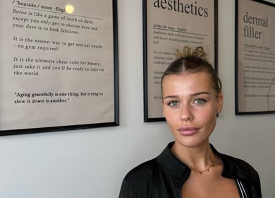 Stylish woman at Blacks clinic in Watford, England, GB, with aesthetic wall art.