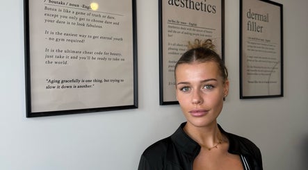 Stylish woman at Blacks clinic in Watford, England, GB, with aesthetic wall art.