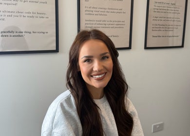 Woman smiling at Blacks clinic in Watford, England, GB, showcasing beauty and wellness atmosphere.