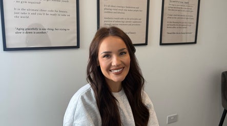 Woman smiling at Blacks clinic in Watford, England, GB, showcasing beauty and wellness atmosphere.
