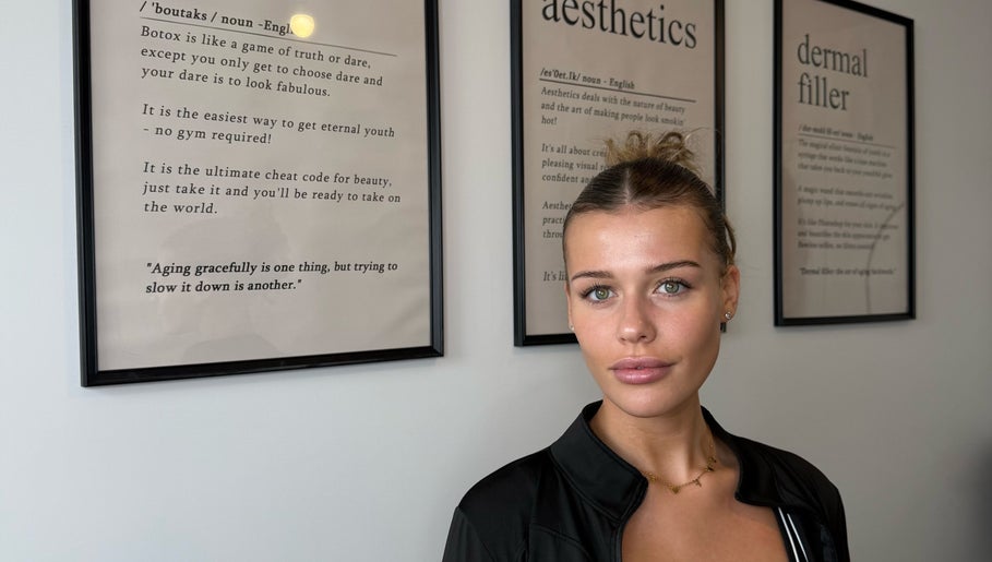 Client at Blacks Clinic, Watford, England, GB, with aesthetic treatments detailed on framed art.