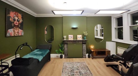 Elegant treatment room at TatiBeauty in Manchester, England, GB with green walls and stylish decor.