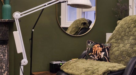 Cozy corner at Tati Beauty, Manchester, England, GB with plush green decor and elegant lighting.