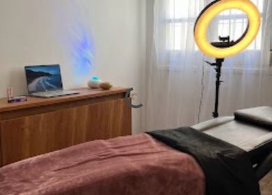Cozy treatment room at Yoss, Montevideo, Departamento De Montevideo, UY with massage bed and ring light.