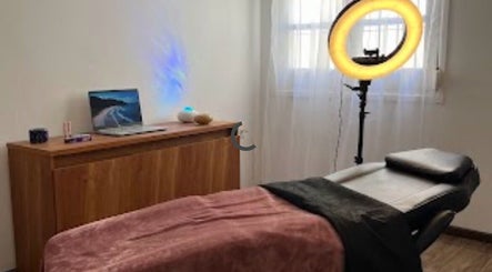 Cozy treatment room at Yoss, Montevideo, Departamento De Montevideo, UY with massage bed and ring light.