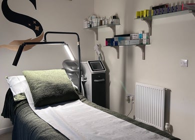 Calm treatment room at SWEY Aesthetics, Milton Keynes, England with treatment bed, products, and ambient lighting.