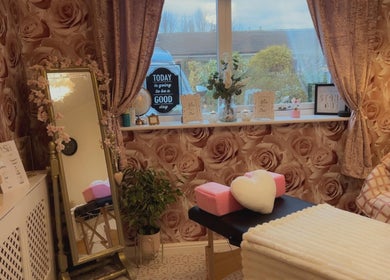 Cozy beauty treatment room at Angela's Beauty, Bradford, England, GB with rose wallpaper and elegant decor.