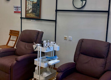 Zona de descanso en ZOE SALON DE UÑAS en Alicante, Comunidad Valenciana, ES con sillas marrones cómodas.