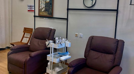 Zona de descanso en ZOE SALON DE UÑAS en Alicante, Comunidad Valenciana, ES con sillas marrones cómodas.