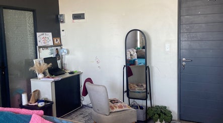 Interior view of Yeu’s Sisterlocs in Kempton Park, Gauteng, ZA, featuring a cozy styling area with a mirror and chair.
